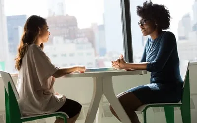 Two women talking across a table