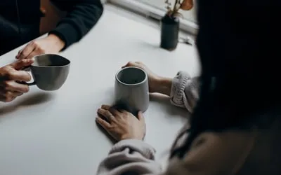 Two people sharing coffee at a kitchen table