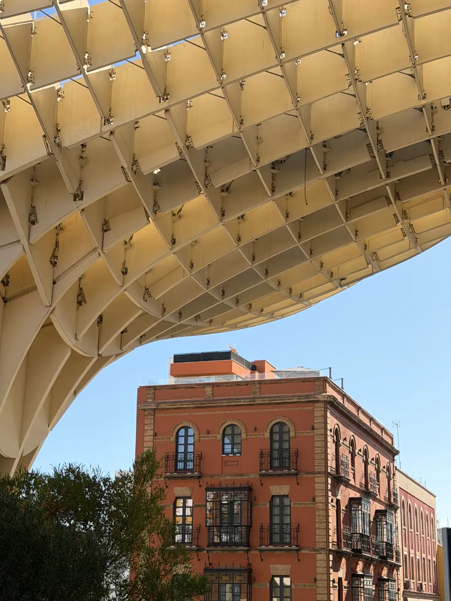 The Setas de Sevilla over an old brick building, against a blue sky
