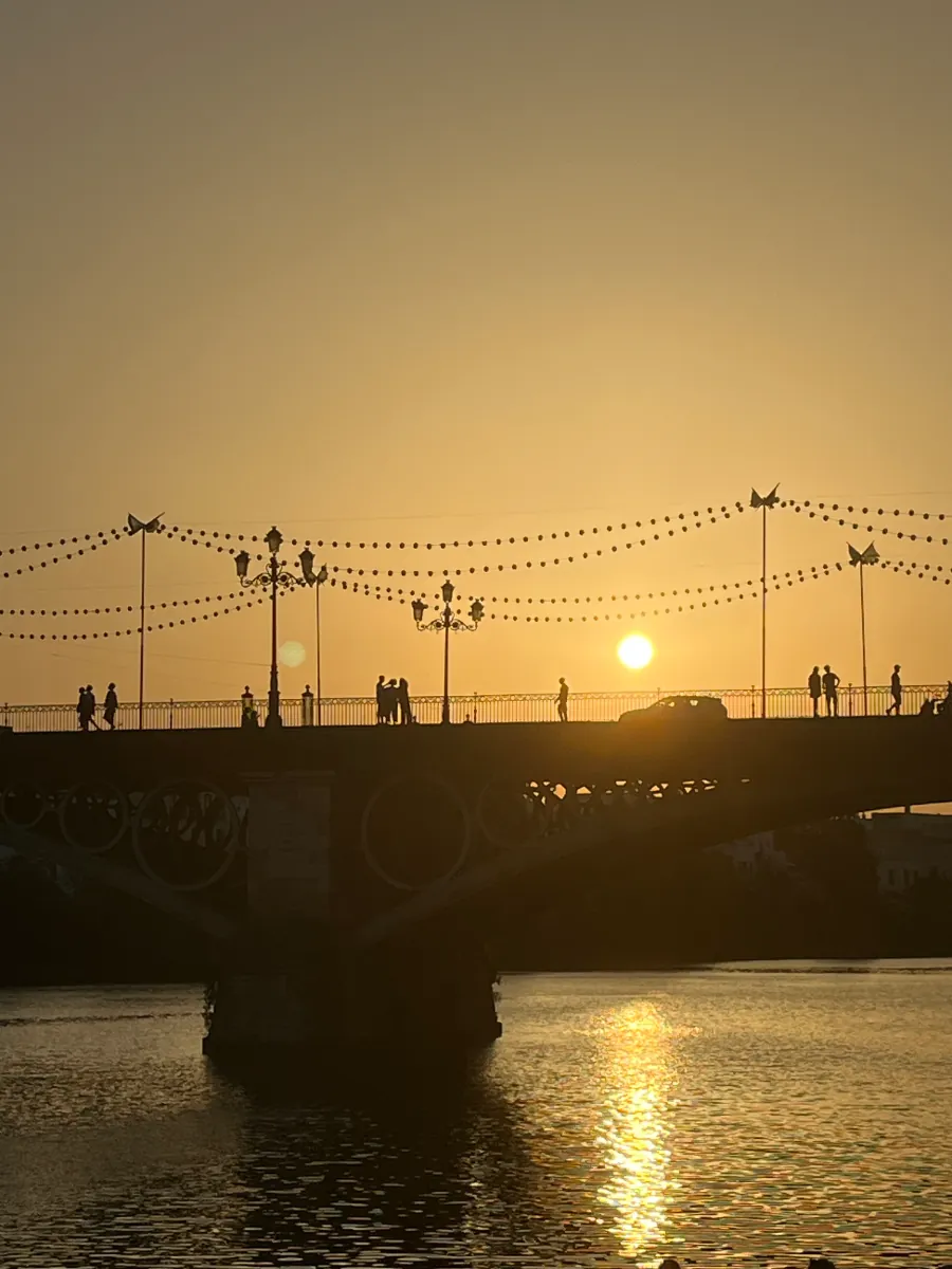 The sun setting over the river and the Triana bridge