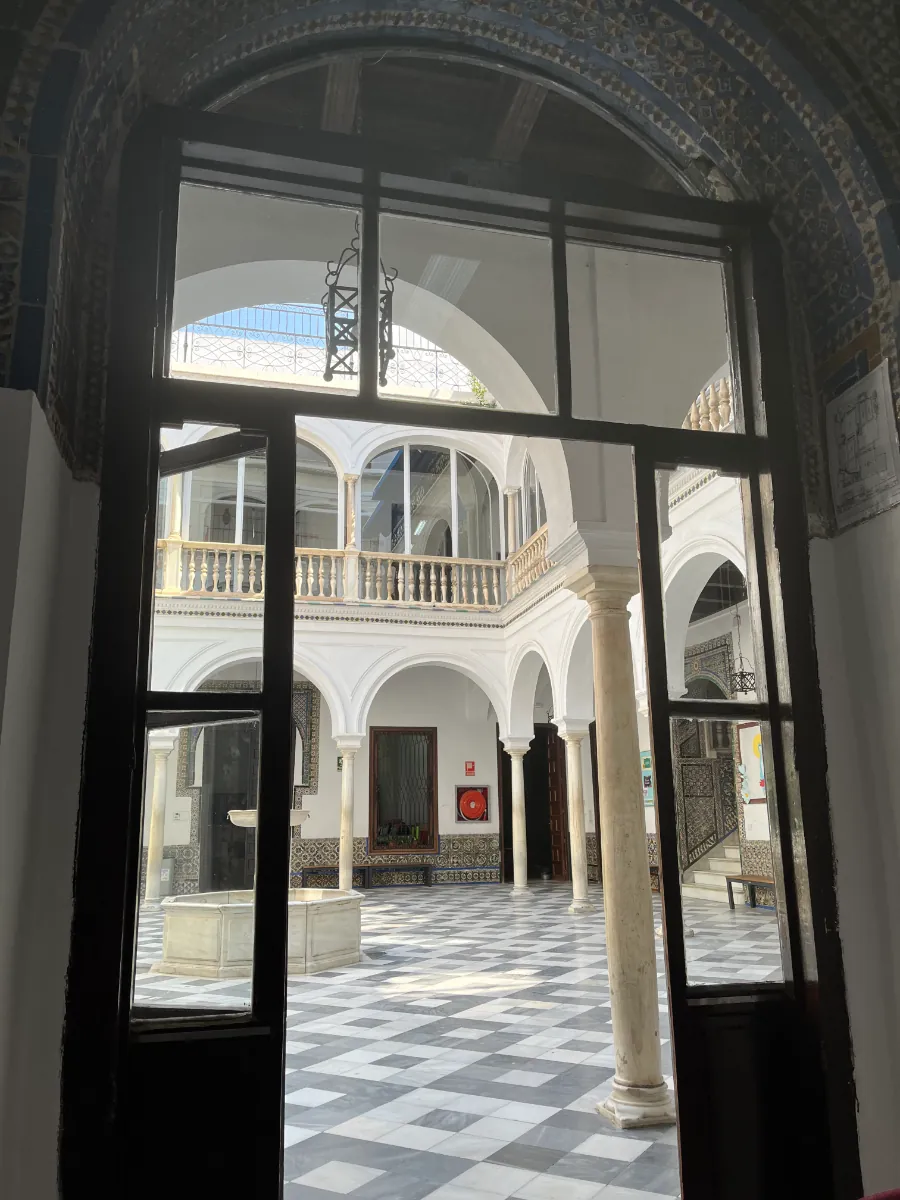 A tiled patio seen through a school doorway in Seville